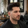Man with a swept-back pompadour and clean low taper fade.